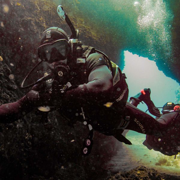 Dykkere som dykker inn en grotte
